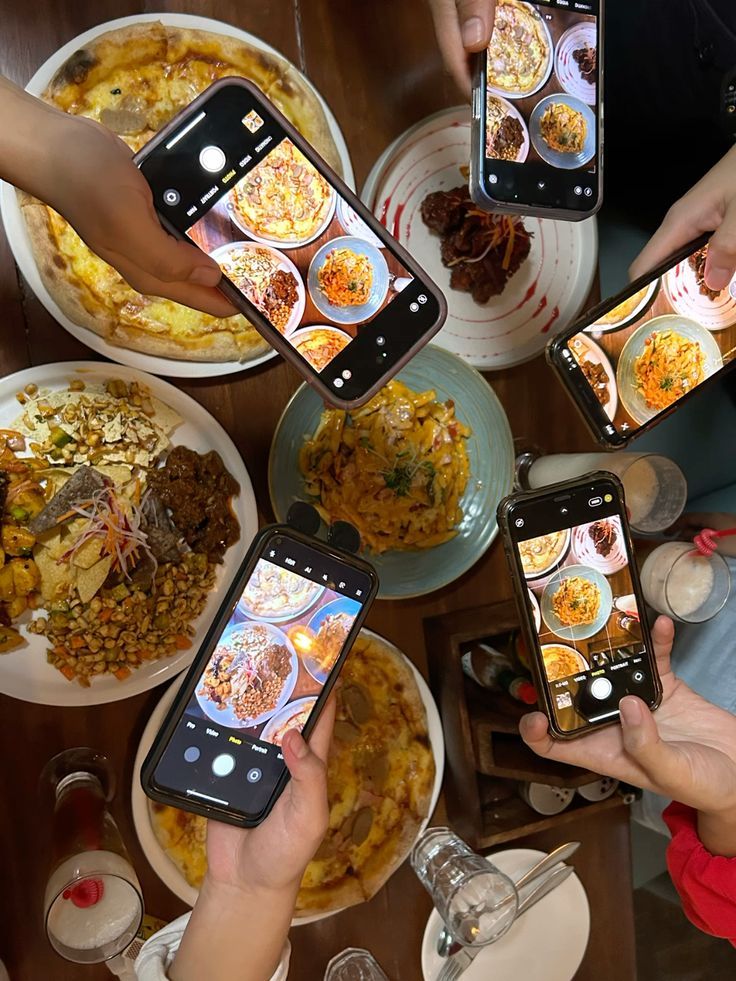 Pessoas fotografando pratos com celulares para compartilhar nas redes sociais